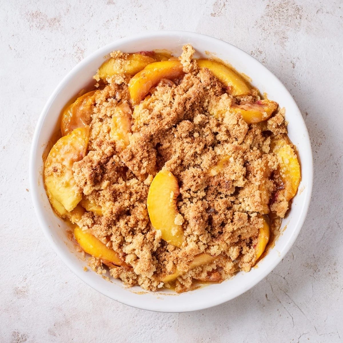 Freshly baked Peach and Ginger Crumble: a sweet, tangy dessert topped with a golden crumble crust.