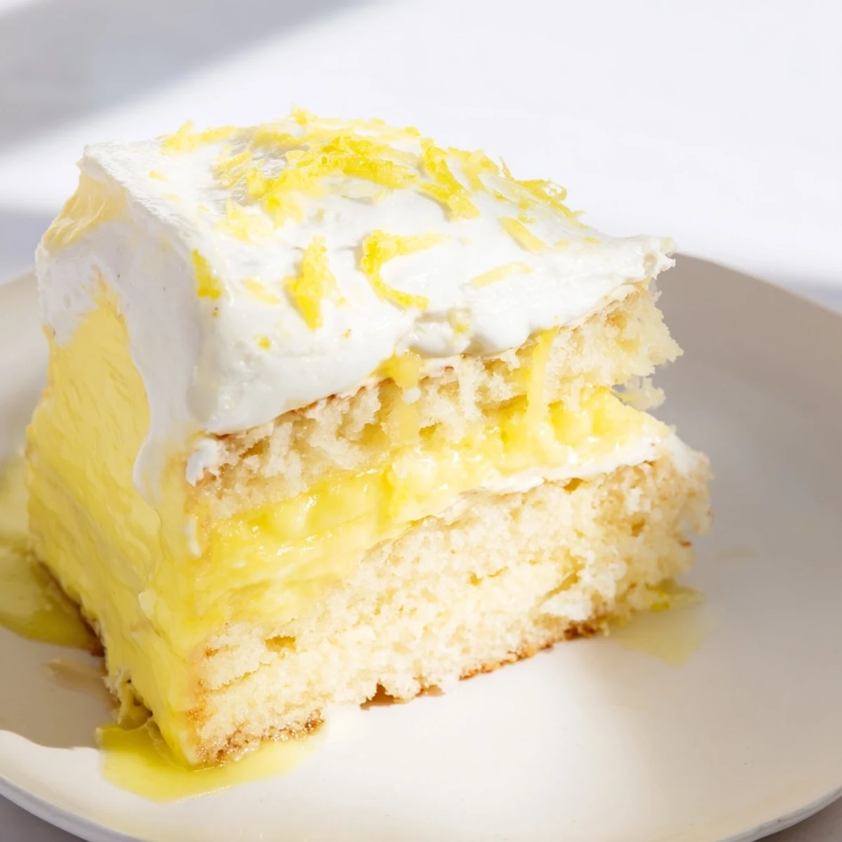 Fluffy lemon loaf cake slice, drizzled with bright citrus icing, ready to enjoy.