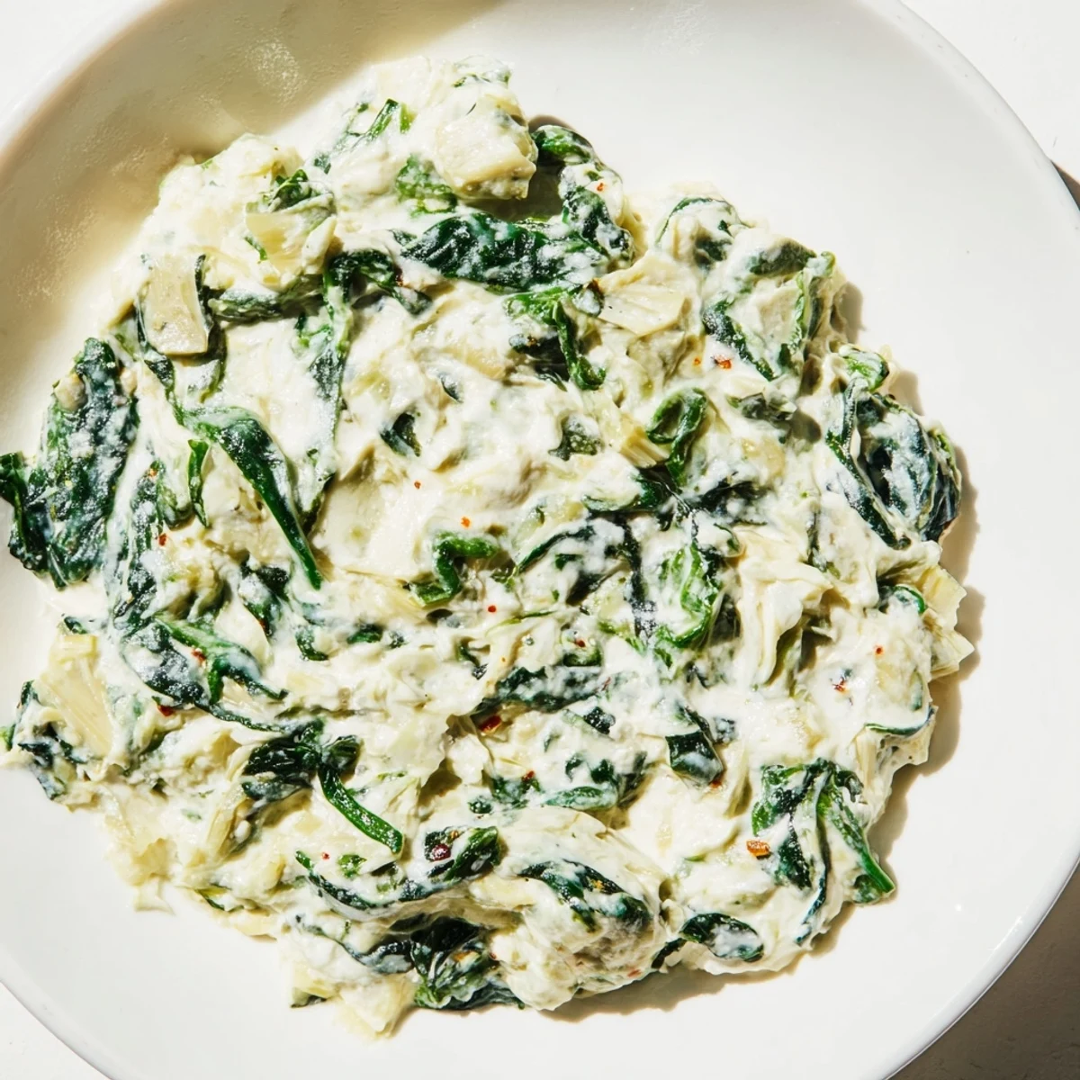 Golden, bubbly spinach artichoke dip, served hot with a platter of crisp tortilla chips.