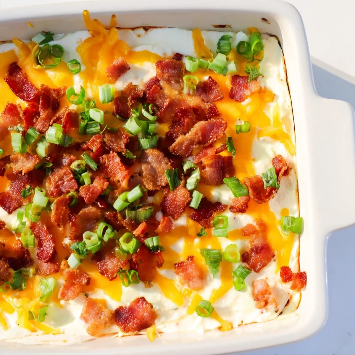 Golden brown, baked Cheesy Bacon Ranch Dip, served hot with crunchy tortilla chips for dipping.