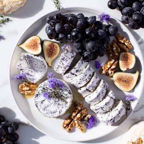 A beautifully arranged Lavender Haze cheese platter with vibrant grapes, figs, and candied nuts.