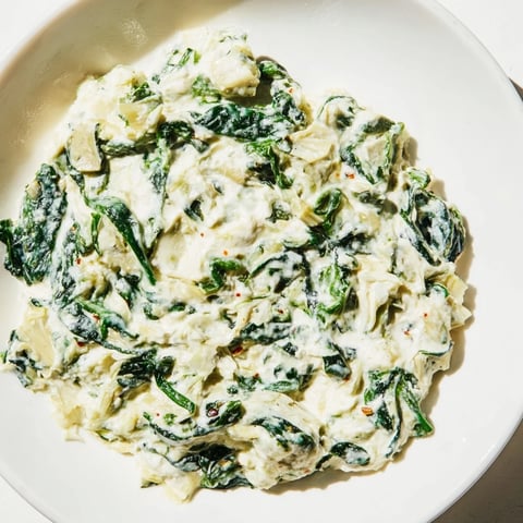 Golden, bubbly spinach artichoke dip, served hot with a platter of crisp tortilla chips.