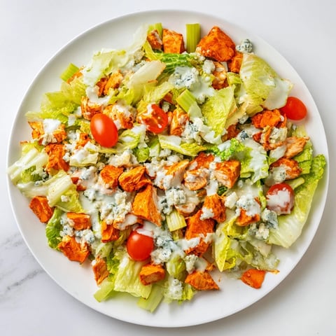 Freshly chopped romaine, spicy buffalo chicken, and creamy blue cheese in a vibrant salad bowl.
