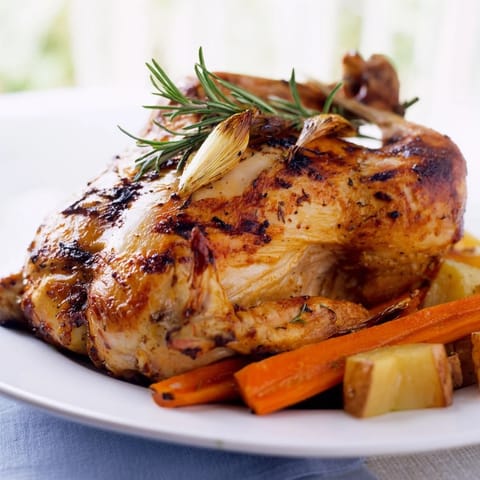 A succulent view: The perfectly roasted Roast Chicken with Rosemary and Garlic, ready to eat with roasted veggies.