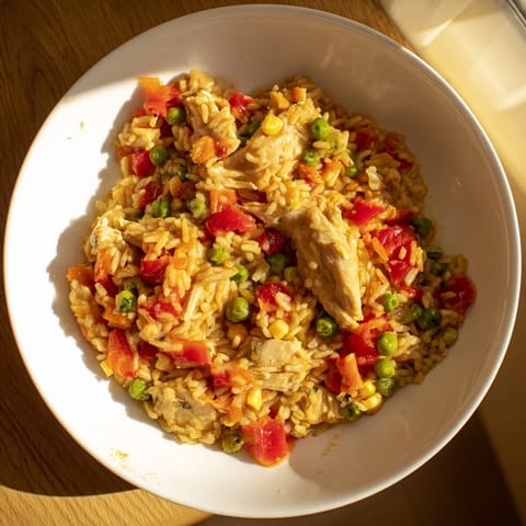 A close-up of the flavorful One-Pot Chicken and Rice, brimming with vibrant vegetables and savory broth.
