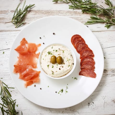 This impressive Compass Rose is a delightful arrangement of meats with olives and herbs.