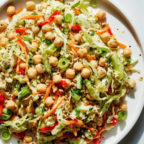 Fresh, vibrant fiber-forward chickpea salad piled high, featuring crisp veggies and a zesty flavor profile.