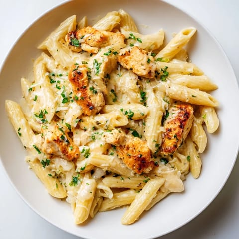 Tender chicken and penne pasta bathed in a flavorful Quick Garlic Parmesan Chicken Pasta dish.