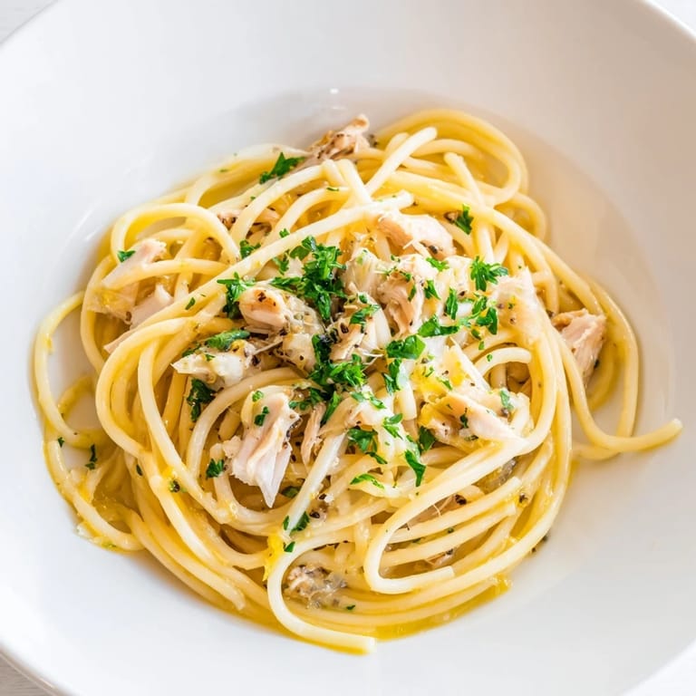 Tender shredded chicken tops the Simple Garlic Butter Bucatini, a quick and delicious Italian meal.
