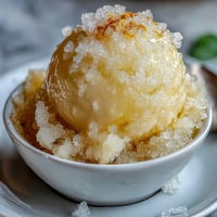 Vibrant limoncello sorbet in chilled glasses, garnished with fresh mint leaves and lemon zest, perfect for summer gatherings.